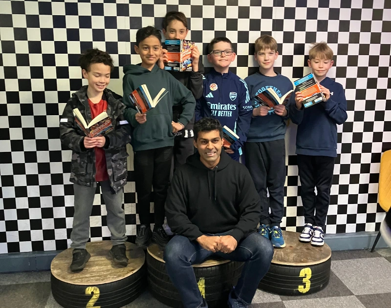 Karun Chandhok and children on a racing podium at Absolutely Karting.