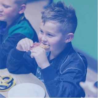 Small child enjoying the pizza at the kids karting party